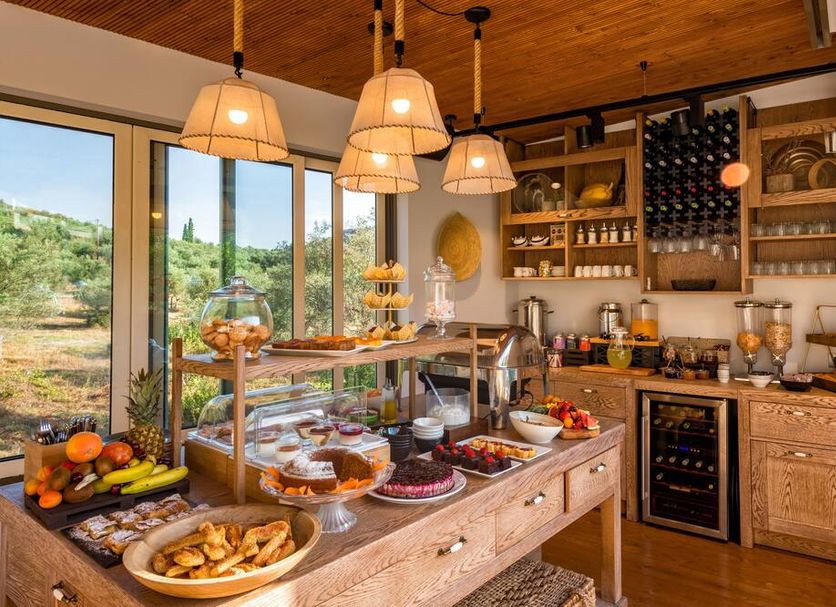 Breakfast buffet at Anthemion Suites & Villas in Náfplio with pastries, fruit, and a wine cooler