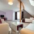Empress Hotel Munich attic suite with sloped ceiling, seating area, and twin beds