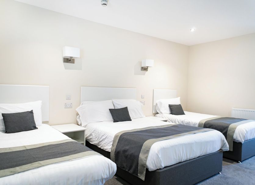 The Appleby Inn Hotel in Swadlincote: triple guest room with three single beds and wall lights