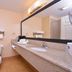 Quality Inn & Suites Williamsport bathroom with sink, mirror, toilet, and towel shelf