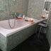 Il Riposo del Guerriero Guesthouse in Genoa: mosaic-tiled bathroom with bathtub, handheld shower and stool
