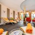 Schlosshotel Lacknerhof in Flachau spa relaxation room with loungers, red chairs and arched windows