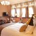 Hotel Boutique Castillo Rojo Santiago guest room with bed, desk, TV and large sunlit windows