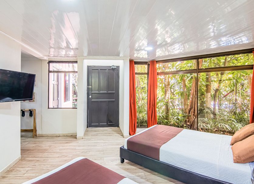 Jaco Lodge Quiet Place in Jacó guest room with two beds and large garden-view windows
