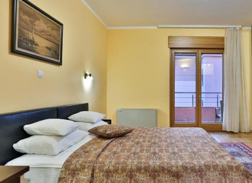 Hotel Stella di Mare in Bečići guest room with double bed, balcony doors, and wardrobe