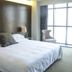 Zhuhai Zobon Art Hotel room with king bed, armchair and floor-to-ceiling windows in Zhuhai