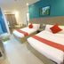 Legazpi Tourist Inn in Legazpi City room with two beds, wall-mounted TV, and balcony door
