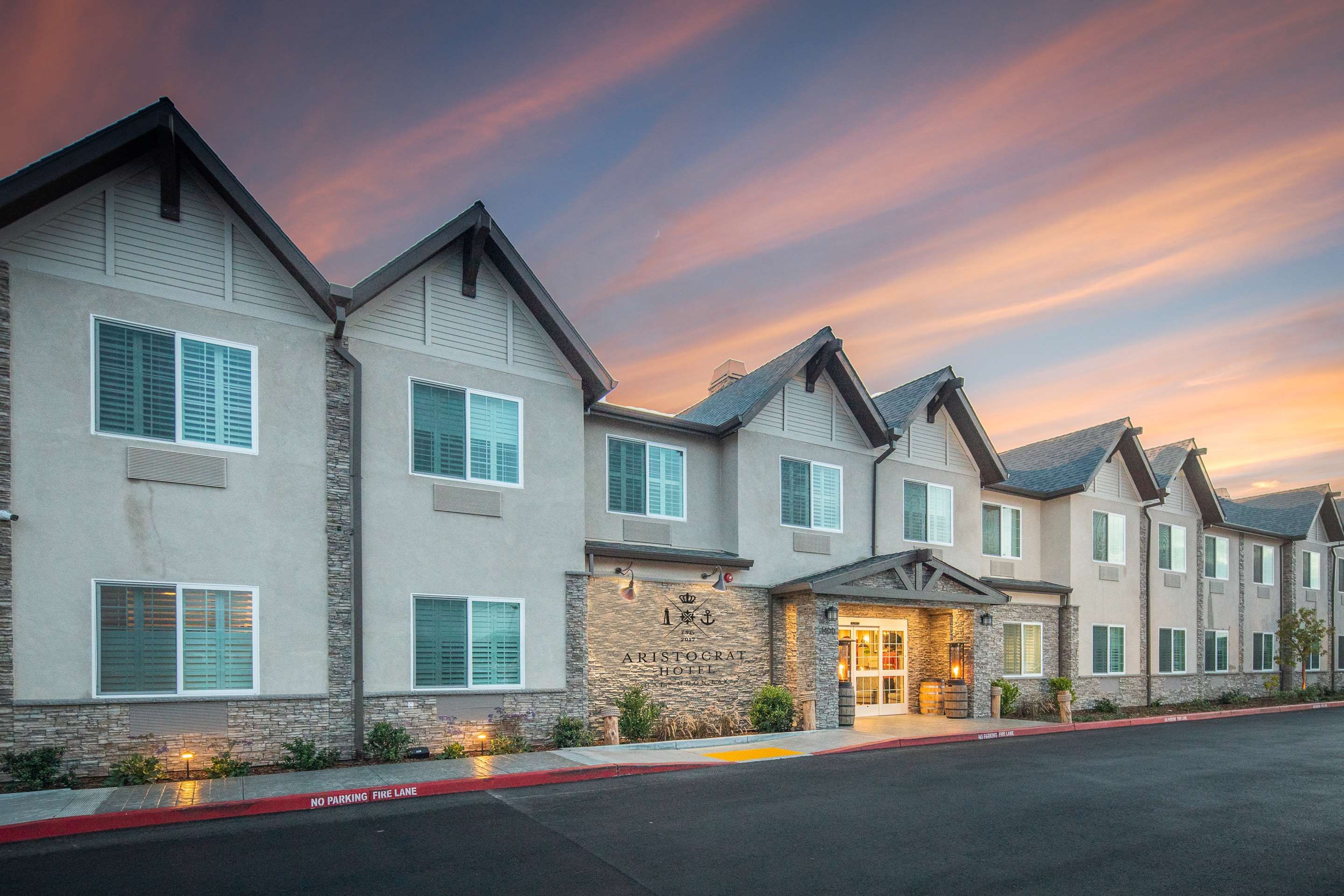 Aristocrat Hotel, BW Signature Collection in Half Moon Bay exterior at sunset with lit entrance