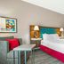 Hampton Inn Junction City guest room with one bed, sofa, and bedside lamps