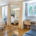 Santiago de Alfama - Boutique Hotel in Lisbon: bright guest room with king bed, mirrored closet, and window seating