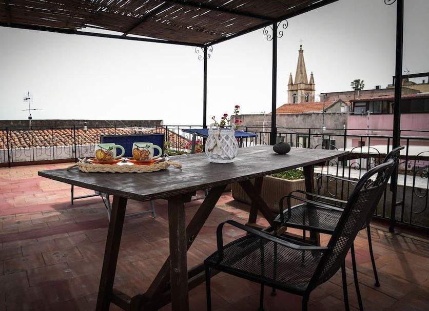 Casa Giuliana in Lipari: terrace dining table with chairs and town views under a pergola