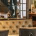 The Stag Rooms Alcester lounge with tufted leather sofa and glass cabinet of trophies