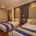 Hotel Jagjeet, Darjeeling: twin beds in a guest room with padded headboards and warm lighting