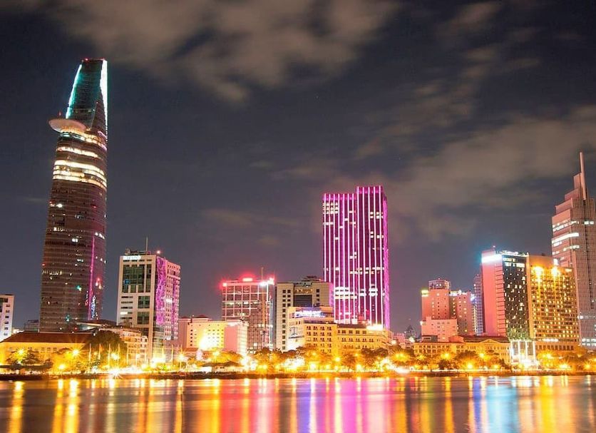 Night skyline view of Ho Chi Minh City near Nicecy Boutique Hotel, with colorful buildings reflecting on water