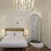 The Stay Galata, Istanbul: elegant white bedroom with chandelier, lamps, and glass shower enclosure