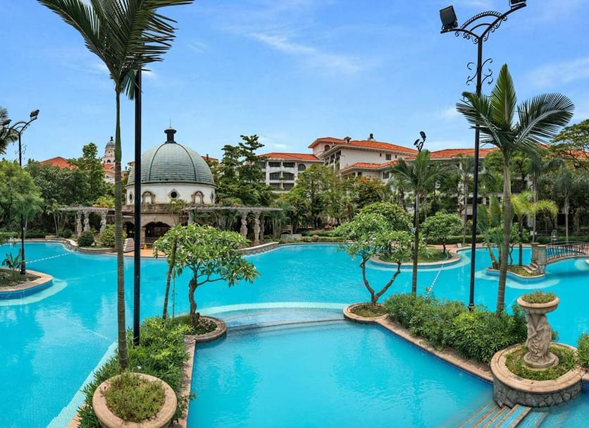 Guangzhou Phoenix City Hotel in Guangzhou with a lagoon-style pool, palm trees, and tropical landscaping