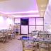 Tr Residency Pondicherry dining area with glass tables, metal chairs and purple ceiling lighting