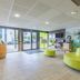 Appart'City Confort Tours lobby with curved green seating and glass entrance in Tours