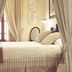Son Mercadal in Porreres: cozy guest room with four-poster bed, curtains, lamp, and patterned rug