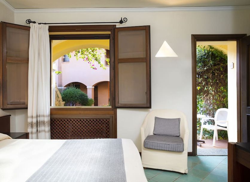 Hotel la Torre in Bari Sardo room with open windows to a courtyard and patio chair