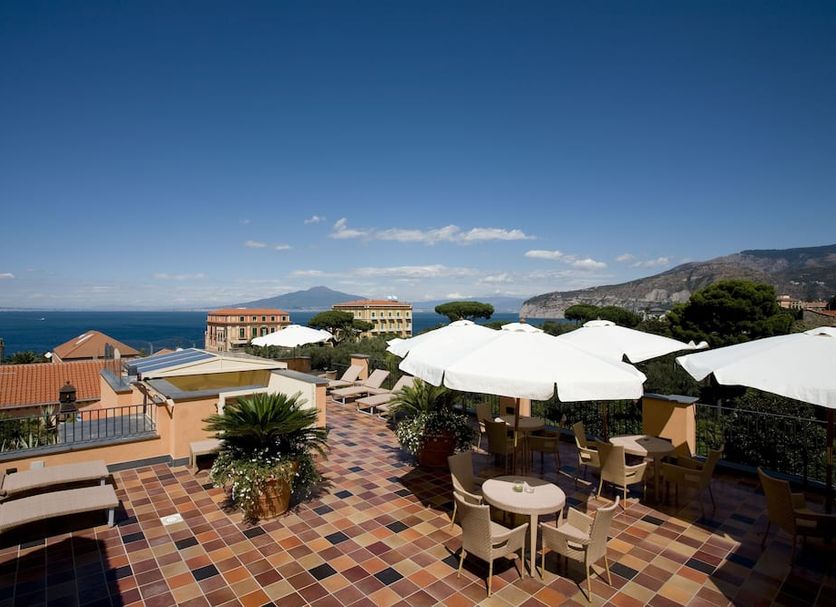 Hotel Palazzo Guardati in Sorrento rooftop terrace with sea view, sun loungers, tables and umbrellas