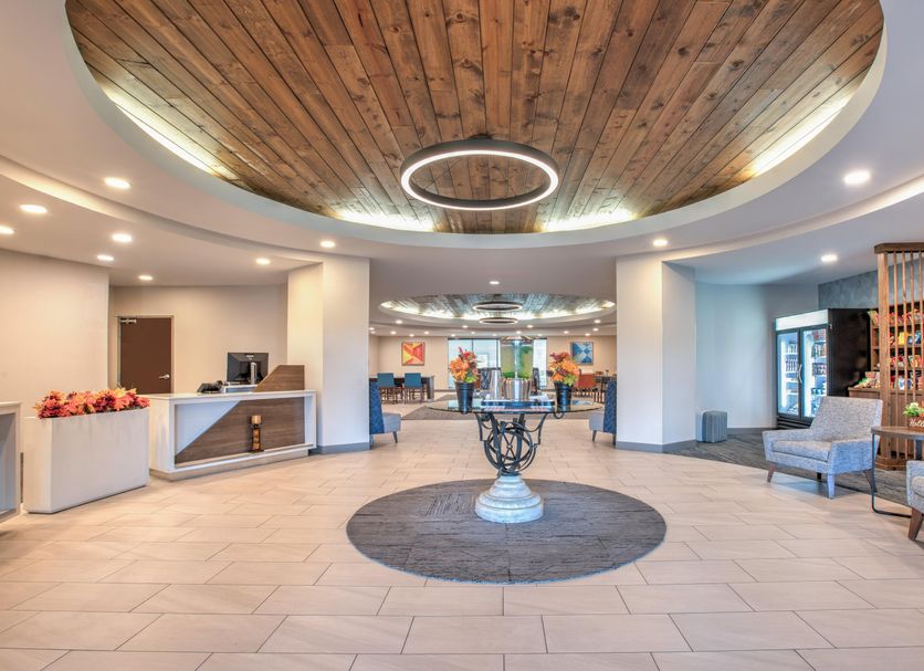 Holiday Inn Express & Suites Zanesville North lobby with wood ceiling, seating area, and reception desk