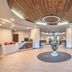 Holiday Inn Express & Suites Zanesville North lobby with wood ceiling, seating area, and reception desk
