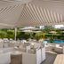 UNA HOTELS Forte dei Marmi outdoor lounge with striped canopy, bar, and poolside seating
