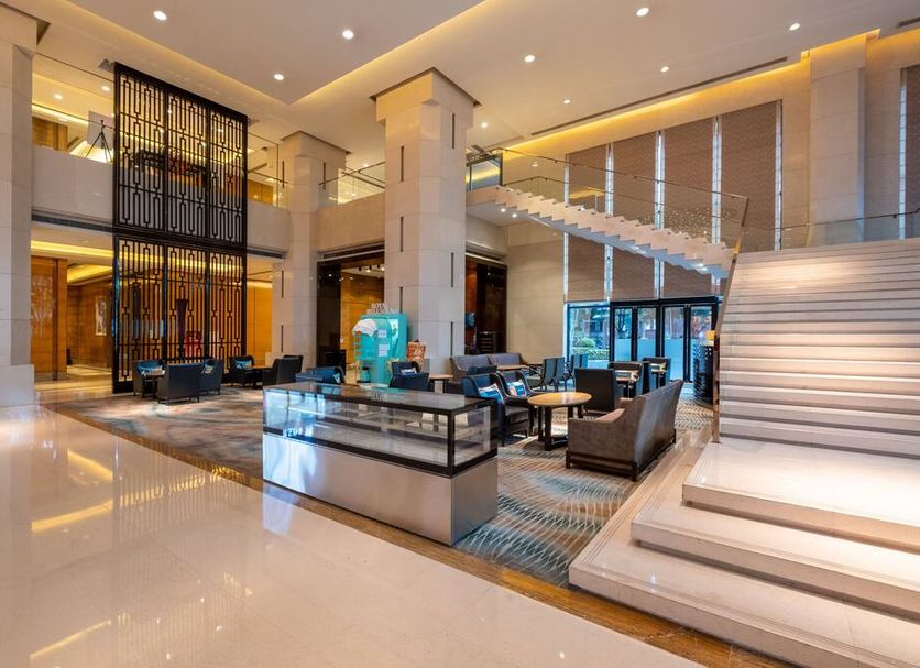 Sheraton Zhongshan Hotel lobby with grand staircase, lounge seating and high ceilings in Zhongshan