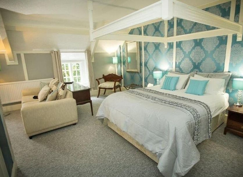 Hardwicke Hall Manor Hotel in Hartlepool bedroom with four-poster bed, sofa and armchairs