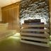 Hotel & Spa Czarny Gron in Rzyki spa sauna with wooden benches, candles and stone accent wall