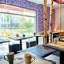NYX Hotel Munich By Leonardo Hotels cafe seating area with large window and birch tree columns