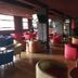 Rainbow Ruiru Resort Nairobi lounge bar with red and tan seating, wood floors, and large windows