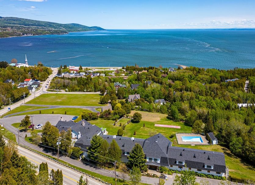 Auberge Des 3 Canards in La Malbaie with ocean view, green grounds, and outdoor pool
