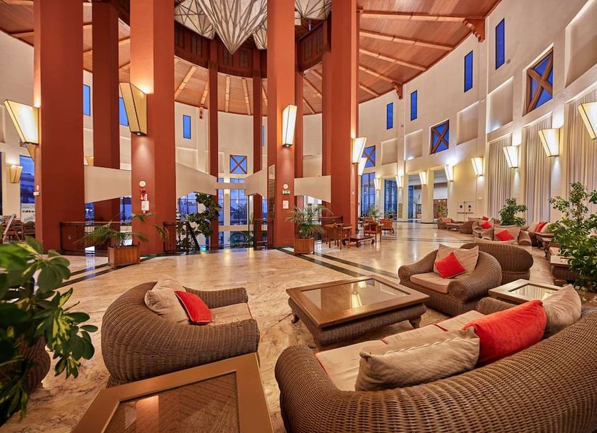 Sandos Papagayo Beach Resort lobby lounge in Playa Blanca with wicker seating and tall atrium windows