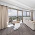 Hotel Grand Chancellor Townsville suite with balcony, city and water views, round table and sofa