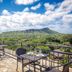 Castle @ Waikiki Grand Honolulu terrace with tables and chairs overlooking Diamond Head and greenery