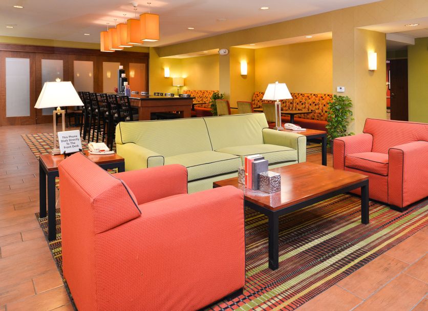 Hampton Inn Yorkville lobby seating area with colorful chairs, sofas, tables, and warm lighting
