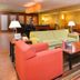 Hampton Inn Yorkville lobby seating area with colorful chairs, sofas, tables, and warm lighting