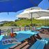 Yeosu Good Morning Pension patio with blue tables, umbrellas, and sea view in Yeosu