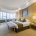 Juneyao International Hotel, Yichang: bright guest room with king bed, city-view windows and seating area