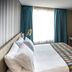 Hotel Plaza Suites Bogotá guest room with queen bed, desk, wall-mounted TV and window with curtains