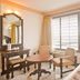 Hotel Sea View in Kanyakumari room with large window, sea view, table and chairs