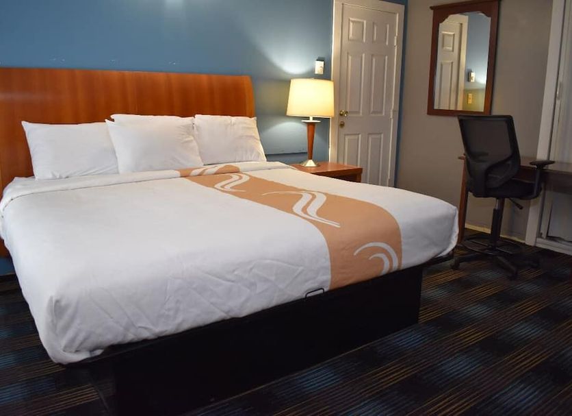 Pilgrim Inn & Cottages in Plymouth guest room with king bed, desk, chair, lamp and mirror