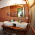 Baia Baia Resort in Ko Phi Phi bathroom with twin sinks, toilet, wood walls, and colorful shower curtain