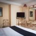 Hotel Santa Maria Mexico City guest room with wrought-iron bed, wall-mounted TV and wall mirror