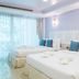 Phranang Place- Sha Extra in Krabi: bright twin-bed hotel room with balcony curtains and wall sconces