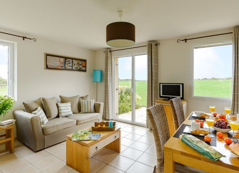 Lagrange Vacances Les Hauts de la Houle in Cancale living room with sofa, dining table and countryside view