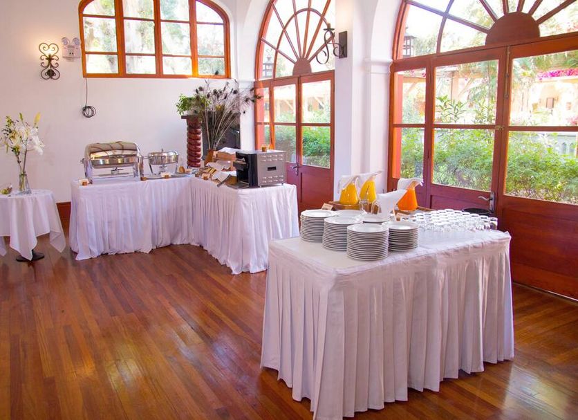Dm Hoteles Mossone - Ica breakfast buffet setup in a bright room with large arched windows