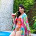 Isabella Boutique Hotel in San Pedro Sula: woman in colorful resort wear by a pool holding a drink